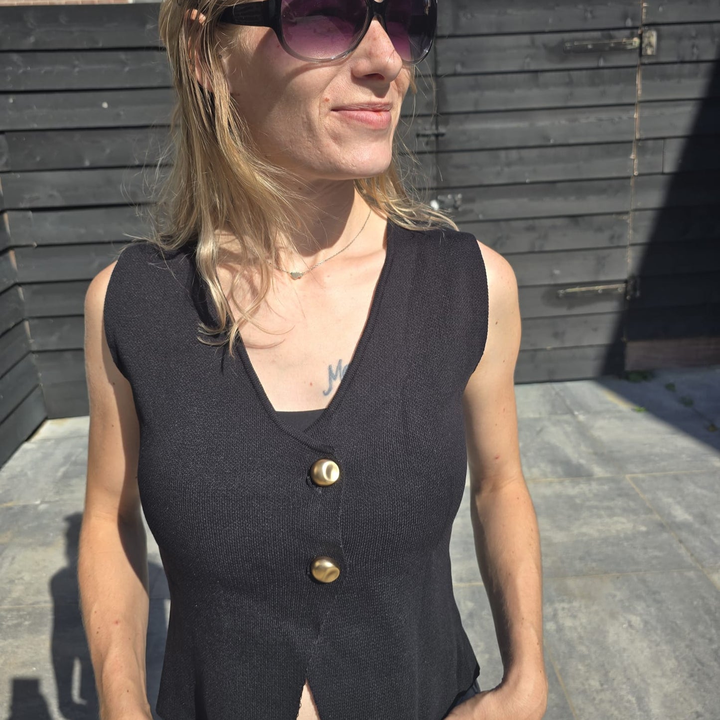 Zwarte top met knoopsluiting, stijlvol en veelzijdig